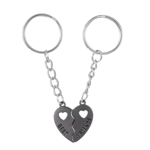 Close-up of gunmetal magnetic split heart keychains with engraved BEST FRIENDS text