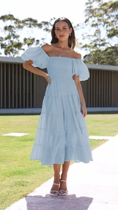Close-up of light blue off-shoulder floral dress with puff sleeves and tiered skirt detail
