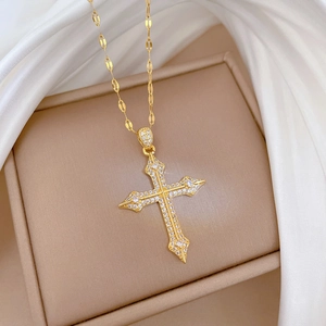 Luxurious gold cross necklace with micro-paved zircons on a white silk background