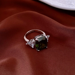 Macro view of adjustable silver ring with square green zircon and triangle side stones