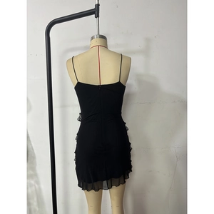 Close-up of black spaghetti strap dress with delicate lace trim and ruffled hem detail