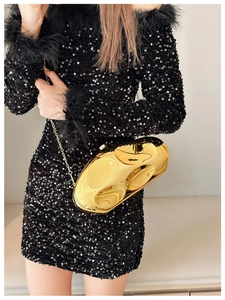 Close-up of golden irregular stone clutch bag with sleek metal chain and mirror finish