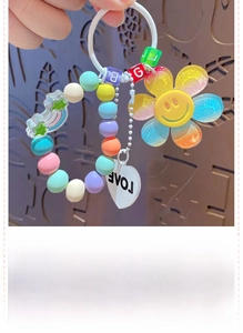 Macro detail of rainbow beaded keychain with smiley sunflower and LOVE heart charm