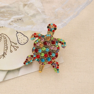Gros plan détaillé d'une broche tortue dorée avec des strass colorés et artisanat soigné