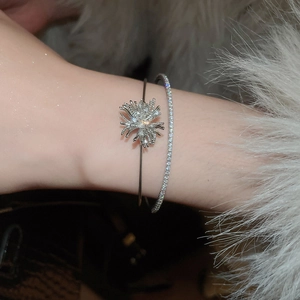 Detail of silver layered zircon bracelet with sparkling firework and starburst motifs