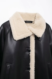 Close-up of contrast faux leather jacket showing plush shearling collar and button detail