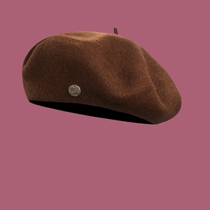 Detailed macro view of wool texture and silver metal buckle on dark brown beret hat