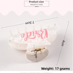 Close-up of white marble pattern hair claw clip with pink Bride lettering and size specs