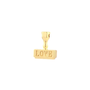 Macro shot of gold vintage coin pendant featuring LOVE engraving and zircon inlay detail