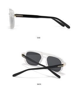 Detail view of vintage sunglasses with matte white frames and gold T-shape metal accents