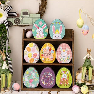 Flat egg-shaped Easter tin boxes with bunny patterns and festive decorations on a wooden shelf
