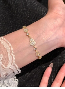Détail macro du bracelet gourde plaqué or 18 carats avec perles et zircon au poignet