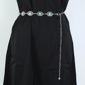Detail of silver bohemian metal waist chain with turquoise stones on black attire