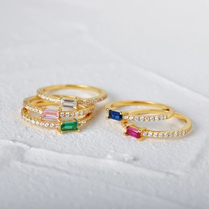 Detailed close-up of stackable gold rings featuring colorful rectangular gemstones