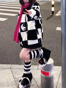 Detail view of Y2K style black and white striped knitted leg warmers with fuzzy sneakers