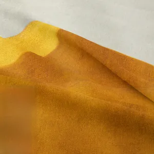 Macro shot of high-density bohemian tapestry fabric showing orange and grey fiber texture