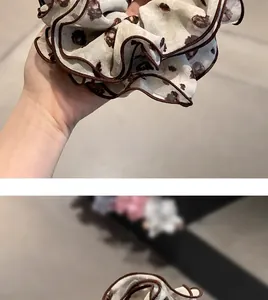 Close-up of leopard print chiffon scrunchie with brown piped edges and soft textures