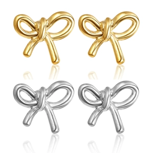 Vue macro détaillée de boucles d'oreilles en métal en forme de nœud, doré et argenté
