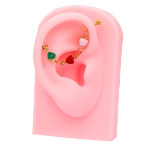 Detail of gold industrial barbell featuring three pink heart enamel charms on an ear model