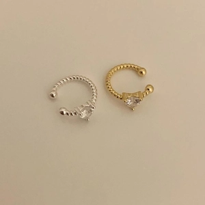 Detailed view of twisted rope ear cuffs with heart-shaped zircon in gold and silver