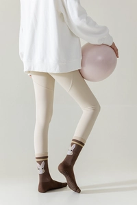 Detail of brown non-slip yoga toe socks featuring cute bunny embroidery with leggings