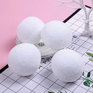 Detailed view of four fluffy white snowball ornaments for Christmas tree decoration
