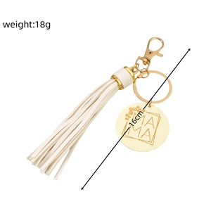 Detail view of MAMA engraved metal charm with white PU leather tassel and lobster clasp