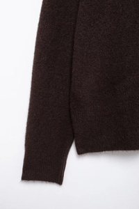 Nahaufnahme von dunkelbraunem Mohair-Strickstoff zeigt weiche Textur und feine Nähte