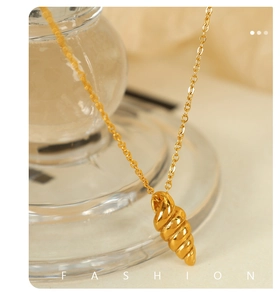 Close-up of a gold conch pendant necklace with polished finish and fine chain detail