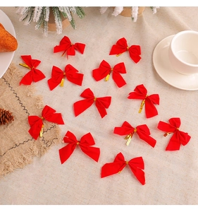 Detailed view of 12 red velvet Christmas bows with gold ties on rustic linen background
