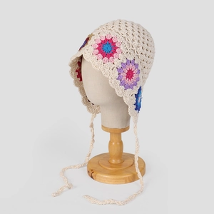 Detail of crochet beanie with vibrant colorful granny square flowers and tie strap