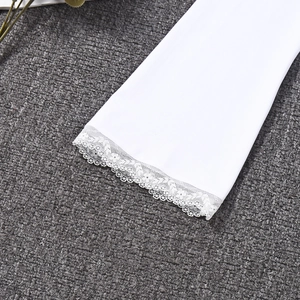 Close-up of delicate white floral lace trim on the sleeve cuff of a slim-fit top