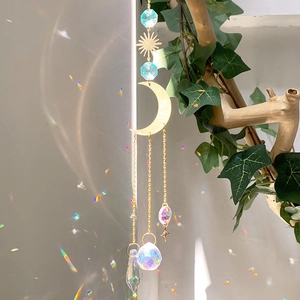 Macro detail of sun and moon crystal suncatcher reflecting rainbow light spots on wall