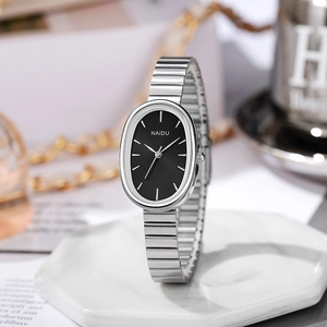 Macro view of a silver oval quartz watch with a black dial and elegant metal bracelet