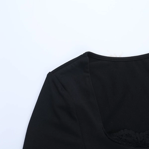 Detail shot of the square neckline with black lace trim on a long sleeve dress