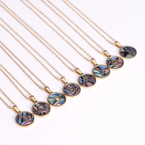 18K gold plated titanium steel necklaces with shell alphabet pendants on white background