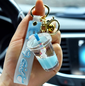 Blue liquid unicorn keychain with silicone wristband and golden bell held in hand