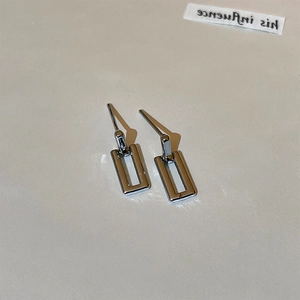 Close-up of minimalist silver rectangular hollow earrings with a sleek geometric design