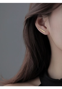 Minimalist gold ear crawler earring on model side view with elegant curved line design