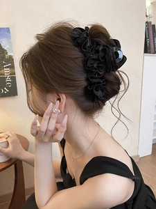 Détail d'une femme portant une pince à cheveux en satin plissé noir pour une coiffure douce