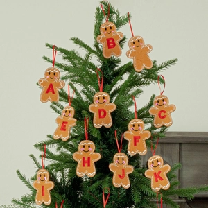 Brown gingerbread man Christmas tree ornaments with red embroidered letters and hanging ropes