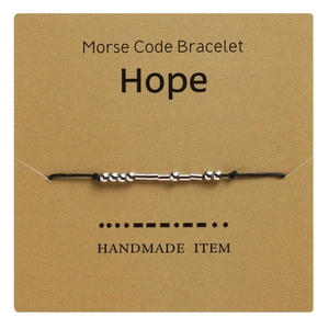 Detail of Morse code bracelet featuring silver beads on a card with the word Hope