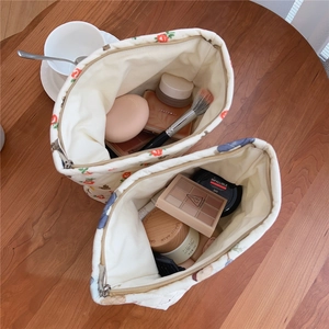 Detail view of the spacious inner storage of a quilted floral bear makeup bag set