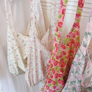 Detalle de bolsos de algodón con varios estampados florales y correas anchas para hombro