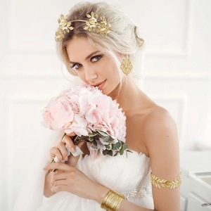 Golden bridal set with leaf headband, armlet and earrings on model with flowers