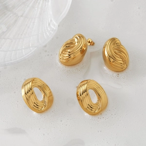 Boucles d'oreilles ovales dorées en acier inoxydable texturé sur surface décorative