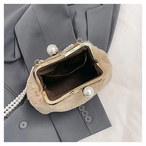 Top view of plush faux fur handbag with pearl handle and golden clasp open to show interior