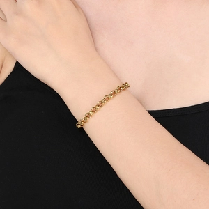 Detailed view of a golden stainless steel Rollo chain bracelet worn on a female wrist