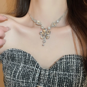 Detail of flower pendant necklace with clear crystals on model neck collarbone