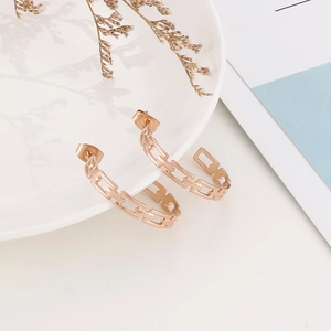 Elegant rose gold stainless steel C-shaped link hoop earrings displayed on white ceramic